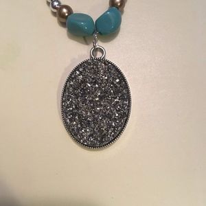 Glittery pendant on a pearl beaded necklace